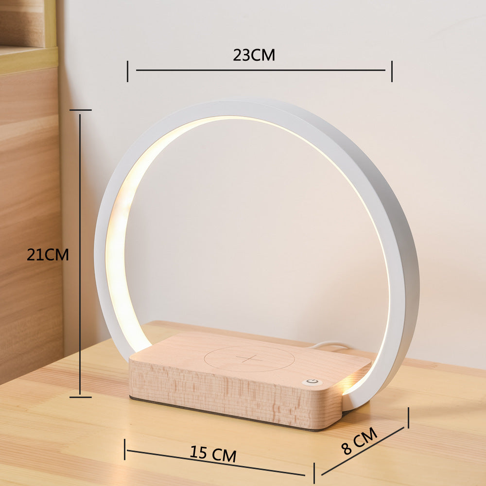 alt="Smart table lamp with built-in clock, temperature display, and phone charging dock"

