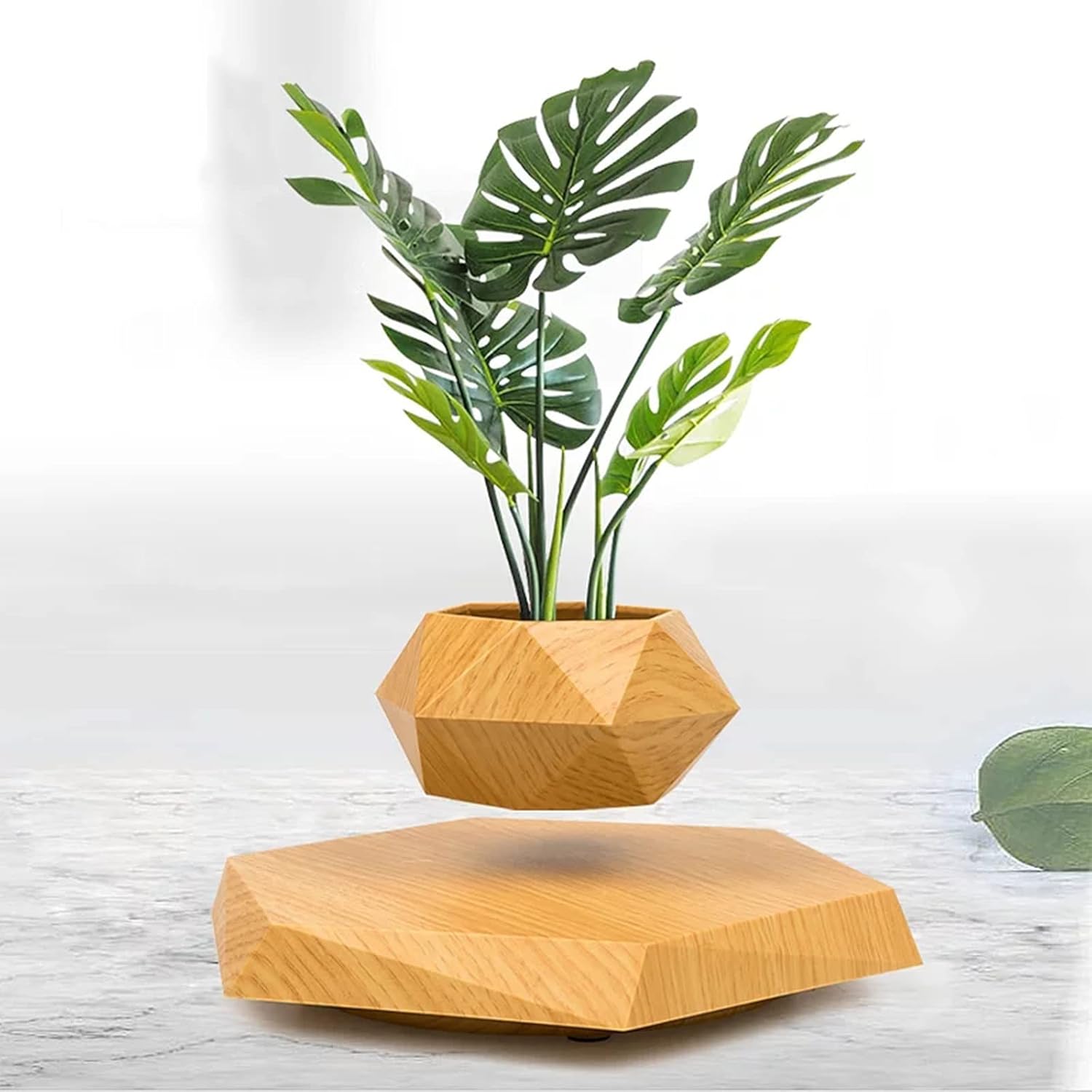 Modern wooden geometric plant pot with green leaves levitating above a matching wooden base. Stylish magnetic floating planter for home or office decor, available at PixelNest7
